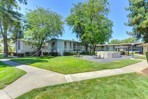 Exterior of the building with large green lawns, walk ways and Trees